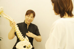 福岡の整骨院で女性院長が骨盤の説明をする様子